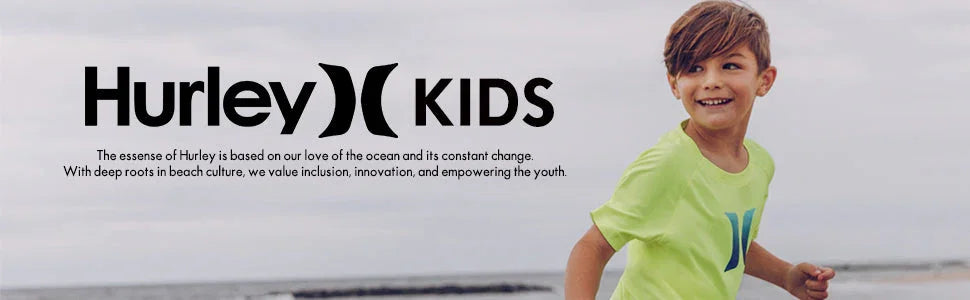 Smiling boy in lime green Hurley t-shirt running outdoors on a beach for kids clothing