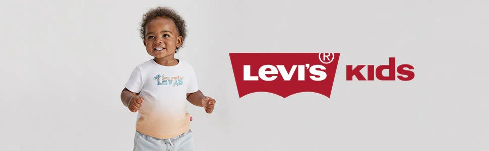 Smiling toddler in branded Levi's kids t-shirt and shorts standing next to Levi's kids logo