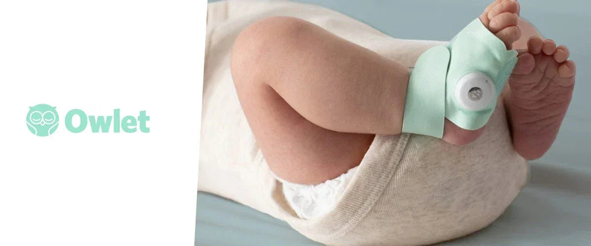 Baby wearing a smart sock monitor on foot, lying on a soft surface, infant care product