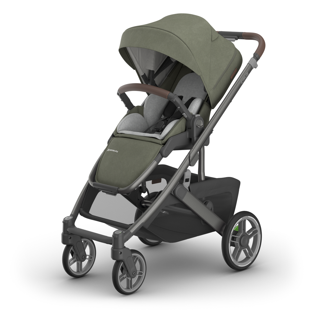 Green baby stroller with canopy, adjustable seat, and brown handlebar, angled view