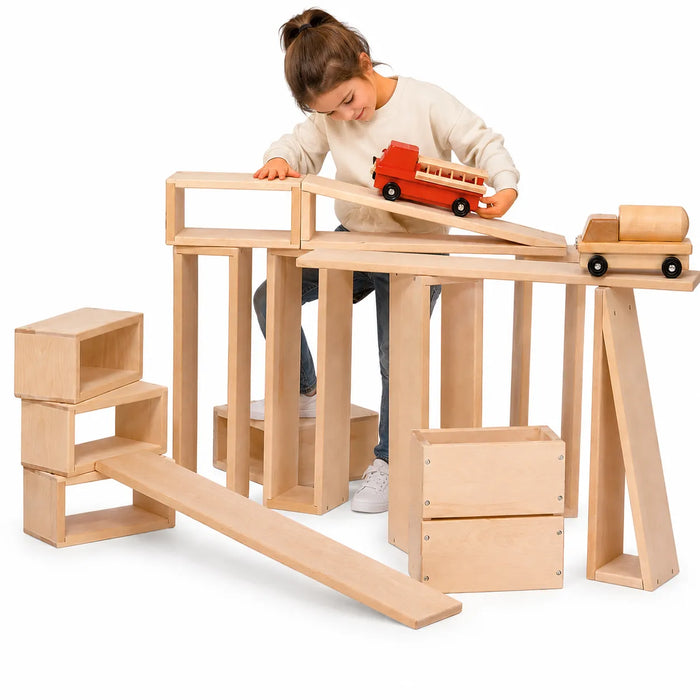 Solid wooden building blocks with a little girl playing with them bulding a road for toy trucks