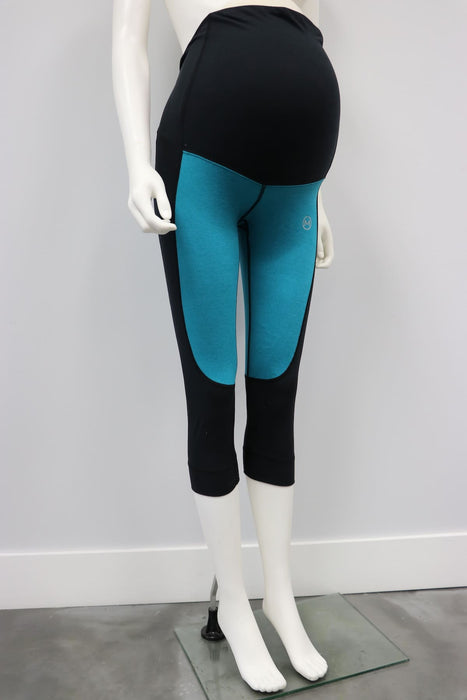 Flex Legging teal and black maternity leggings displayed on a mannequin against a plain wall.