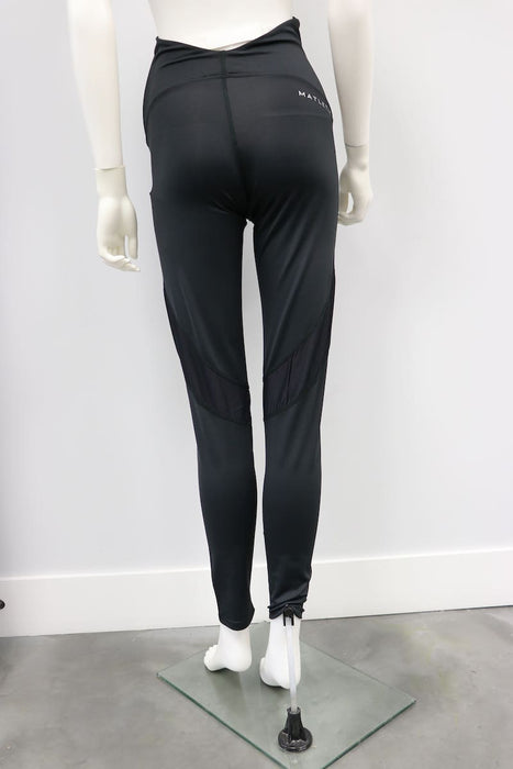 Courage Legging Black shown on mannequin, back view, with mesh panel details in a studio setting.