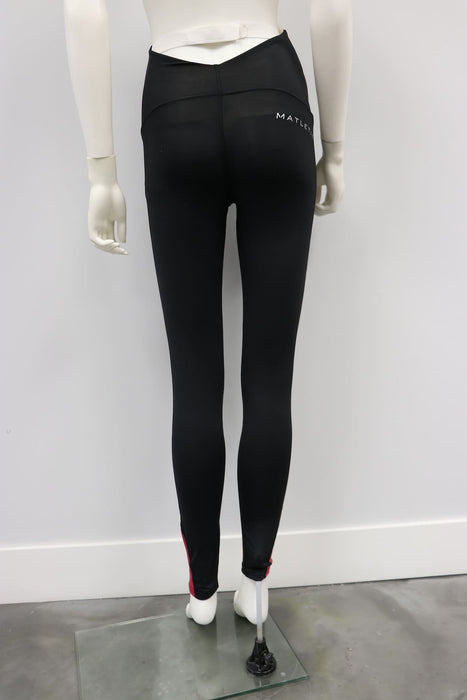 Karma Legging Black-Raspberry shown on a mannequin from the back, in a plain indoor setting.