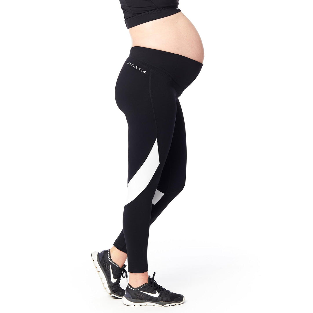 Matletik maternity leggings in black and white, shown worn by a pregnant woman standing sideways.
