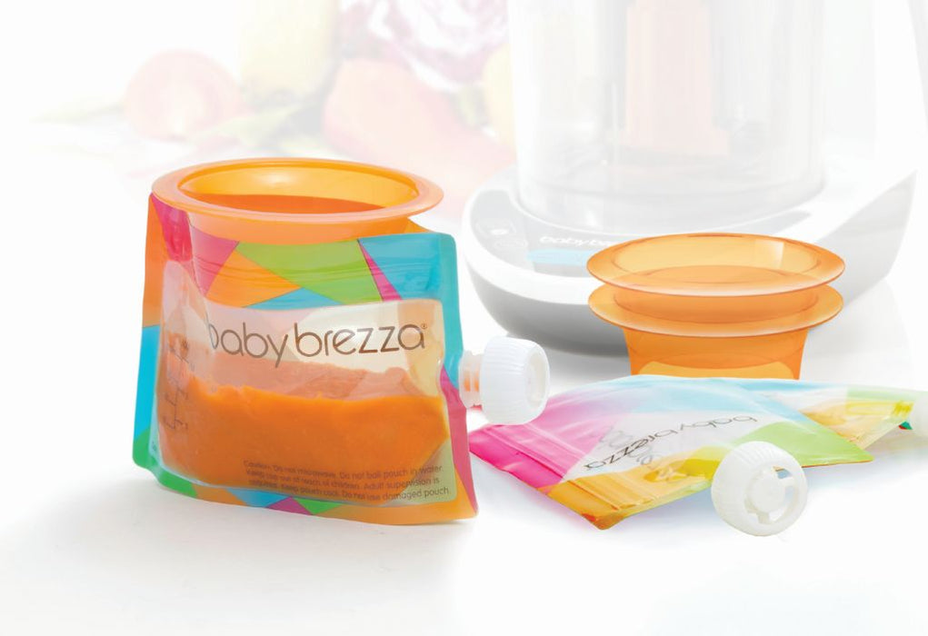 Baby Brezza reusable food pouch filled with pureed food, shown on a clean countertop with caps and funnel.