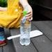 Spout adapter for water bottle held by a child sitting outdoors on a wooden bench.