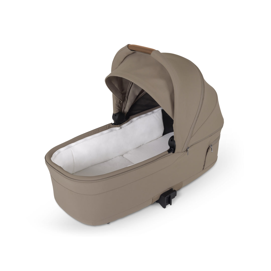 Beige baby bassinet stroller attachment with canopy and white interior on white background