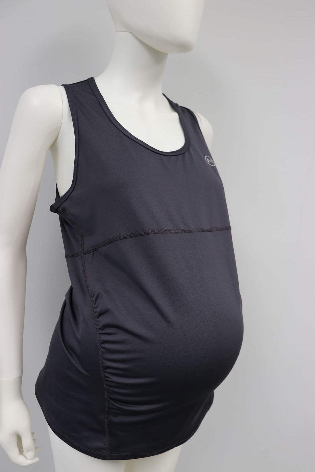 Black maternity tank top with side ruching displayed on a mannequin against a plain background.