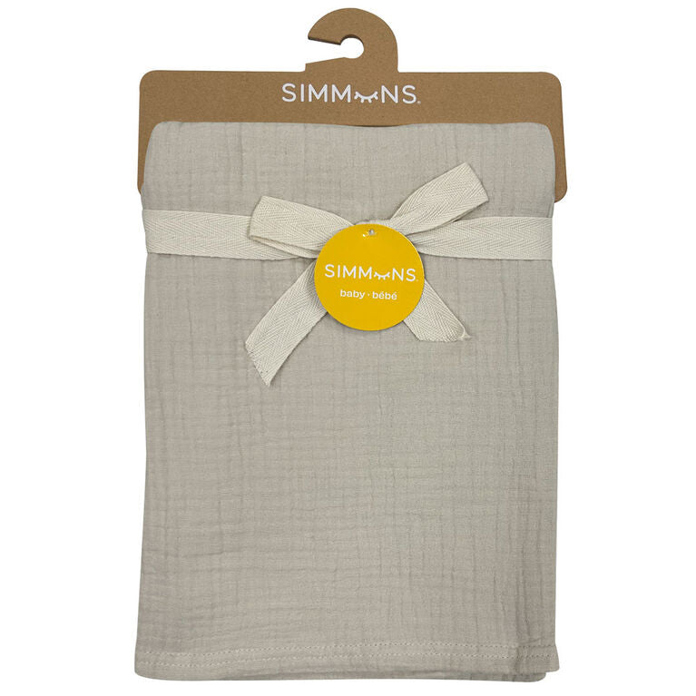 Beige muslin baby blanket neatly folded with ribbon, packaged on a hanger.
