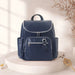Navy blue diaper backpack with silver zippers on a minimal beige background