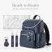 Navy blue diaper backpack with waterproof changing pad, stroller straps, and key chain accessories.