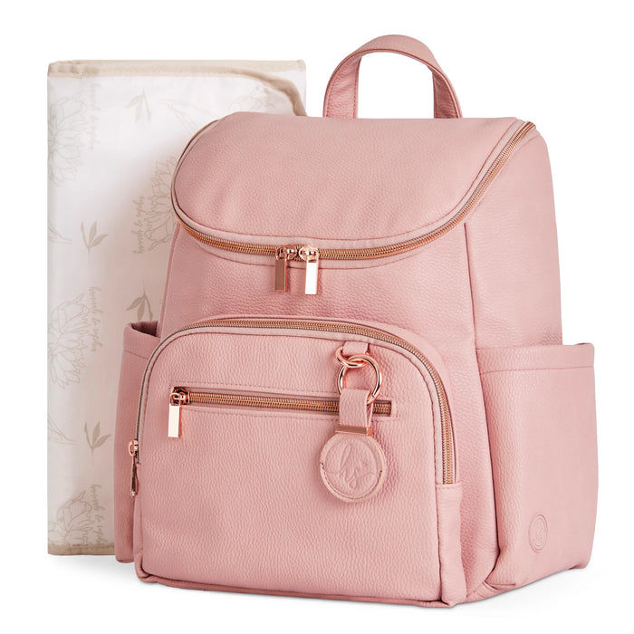 Pink diaper backpack with gold zippers and matching floral changing pad for babies