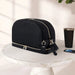 Black quilted diaper bag with gold zippers on a marble table, modern baby accessory