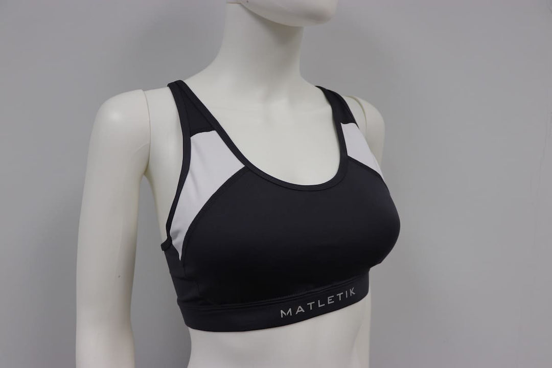 Matletik charcoal and white sports bra top displayed on a mannequin against a plain background.