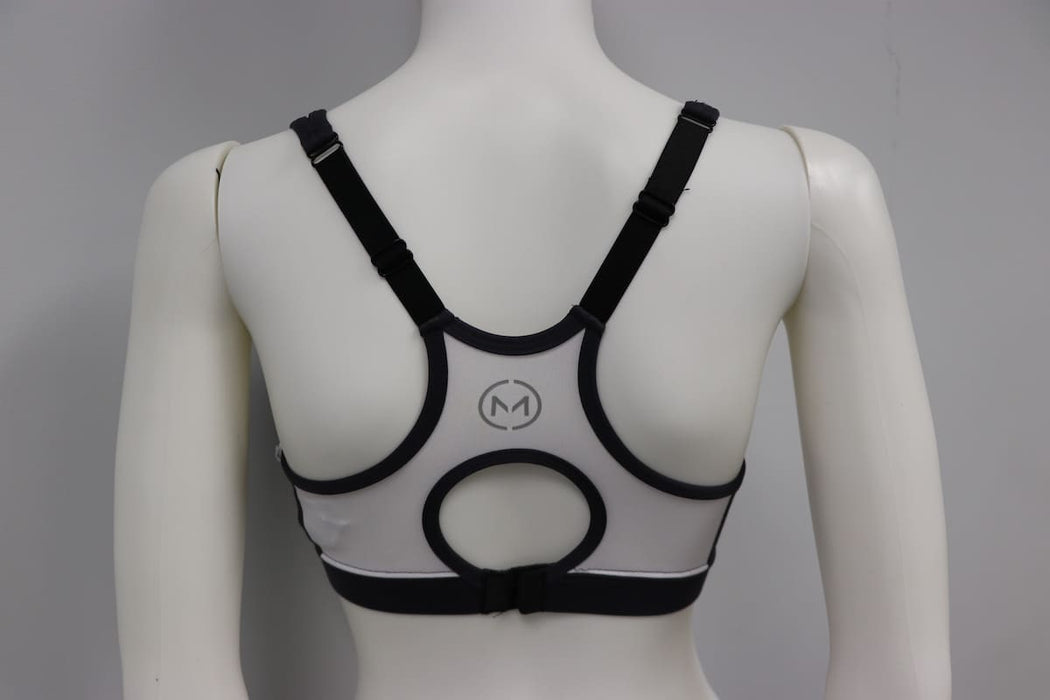 Charcoal and white bra top with black straps shown on mannequin from the back, featuring circular cutout design.
