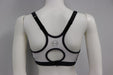Charcoal and white bra top with black straps shown on mannequin from the back, featuring circular cutout design.