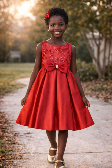 Red party dress with floral embroidery and large bow, shown on a child outdoors on a path.