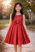 Red party dress with floral embroidery and bow, shown on a girl outdoors in natural light.