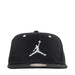Black Jordan snapback cap with white Jumpman logo displayed upright against a plain background.