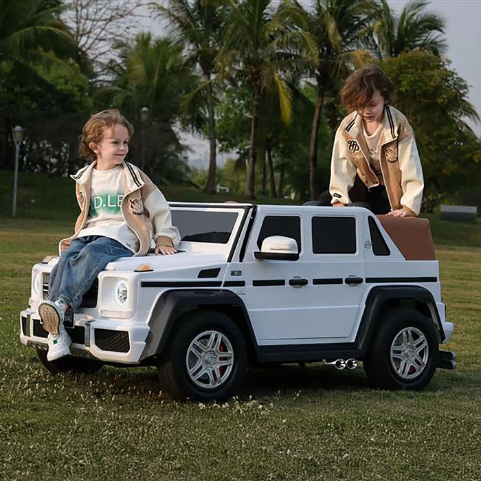 Kids ride-on white toy SUV car with two children playing on it outdoors on grassy field.