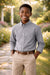 Elevate Oxford Shirt in grey worn by a boy standing outdoors on a garden path.