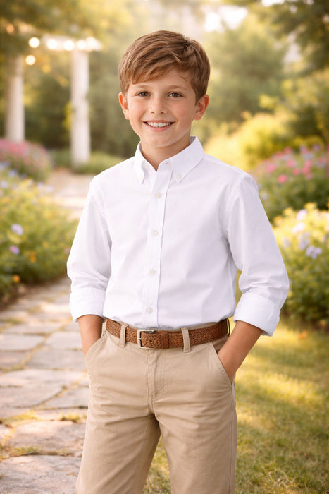 Elevate Oxford Shirt in white worn by a boy standing outdoors in a garden setting.