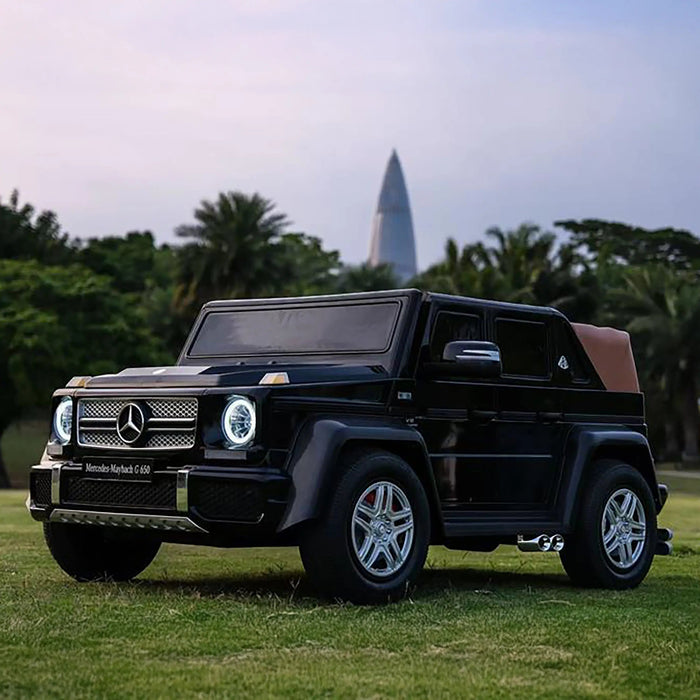Mercedes-Maybach G650 kids ride-on car parked on grass with trees in the background.