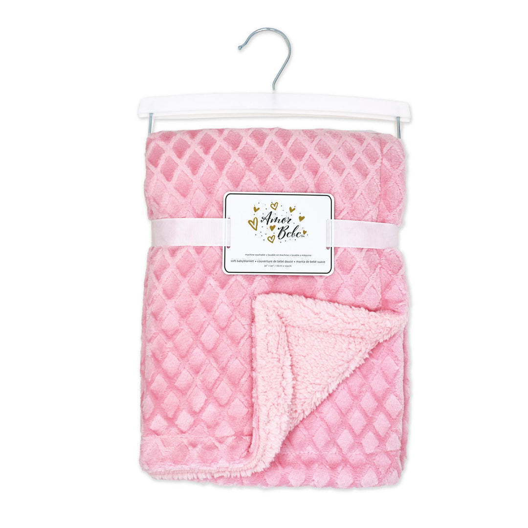 Aimer Bébé pink plush baby blanket with diamond pattern, folded on a hanger against a white background.