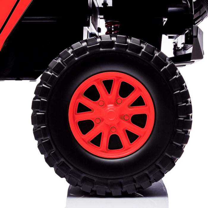 Large black toy truck wheel with bright red spokes shown in close-up on a white background.