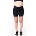 MATLETIK black maternity biker shorts worn by a pregnant model standing on a white background.