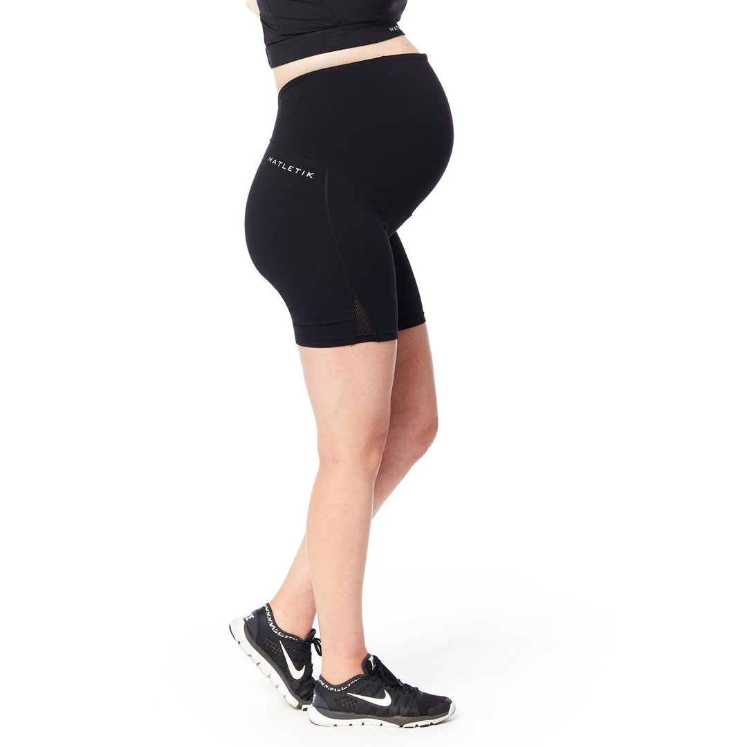 Matletik black maternity biker shorts worn by a pregnant woman standing sideways