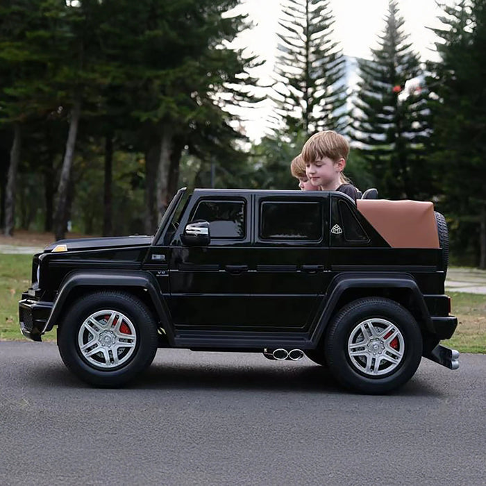 Kids electric ride-on SUV car toy shown outdoors with two children riding on a paved path.