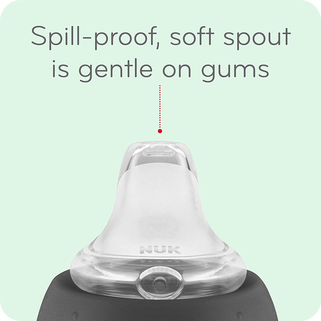 NUK spill-proof baby sippy cup with a soft silicone spout, close-up on light green background.
