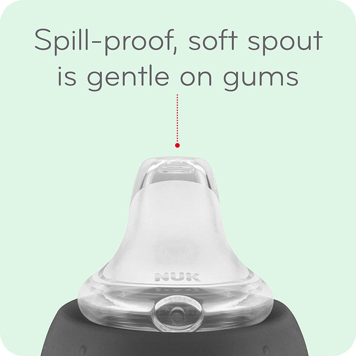 NUK spill-proof baby sippy cup with a soft silicone spout, close-up on light green background.