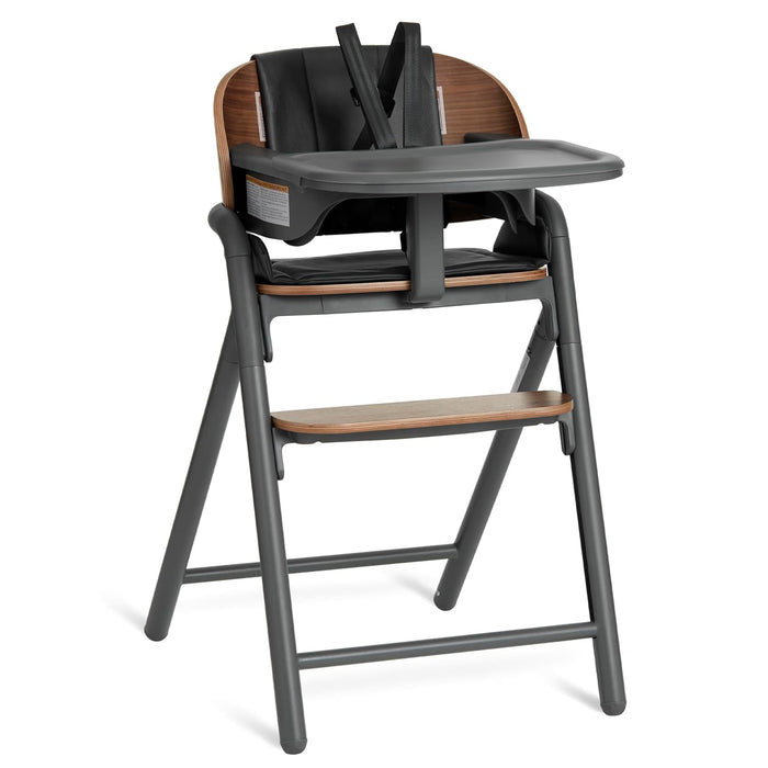 Modern wooden baby high chair with black seat, safety harness, tray, and footrest