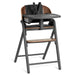 Modern wooden baby high chair with black seat, safety harness, tray, and footrest