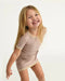 7AM Hug Me Ribbed Knit Dress in ash rose worn by a smiling girl posing against a white background.