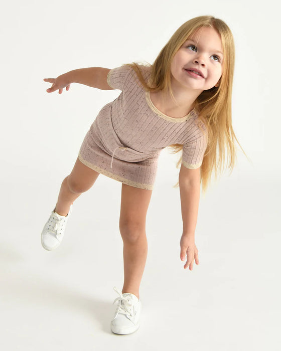 7AM Hug Me Ribbed Knit Dress Ash Rose shown on a smiling child posing playfully against a white background.