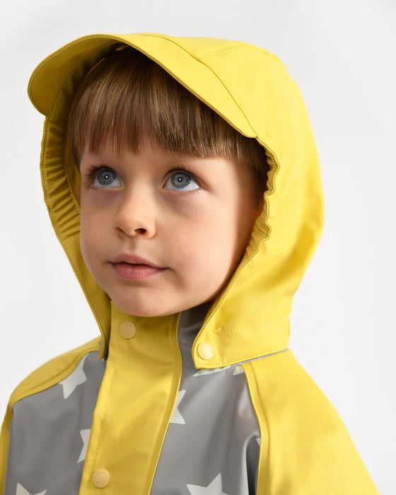 7AM rain coverall shown on a child, featuring a yellow hood and grey star-patterned fabric.
