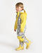 7AM rain coverall with gray star pattern and yellow accents worn by a child standing indoors.