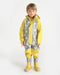 7AM rain coverall shown on a child standing, featuring yellow and grey star pattern with matching boots.
