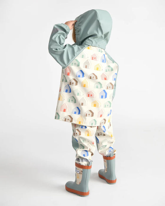 Children's rain jacket and pants set with colorful house print, shown on a child facing away.