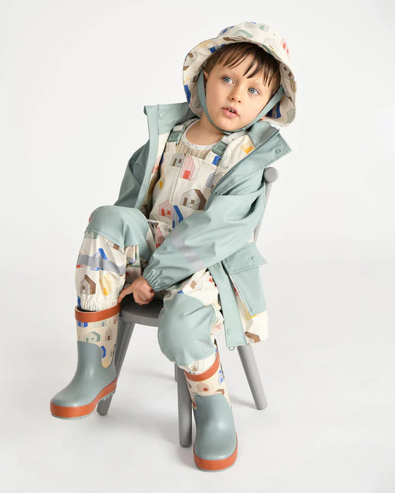 7AM rain jacket kids mint green with matching boots and hat, shown worn by a child sitting on a chair.