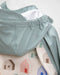 7am rain jacket close-up showing blue waterproof hood and house-patterned fabric detail.