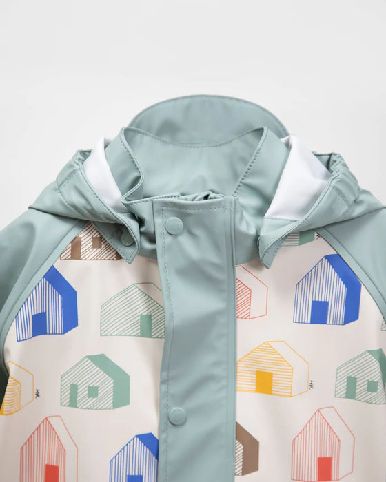 7AM rain jacket with pastel green hood and multicolor house print shown on white background.