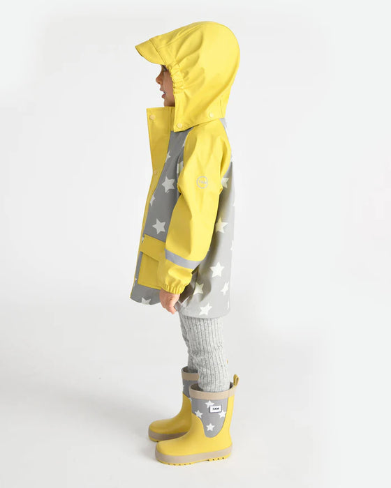 7AM rain jacket in yellow and grey with star pattern worn by a child standing in profile.