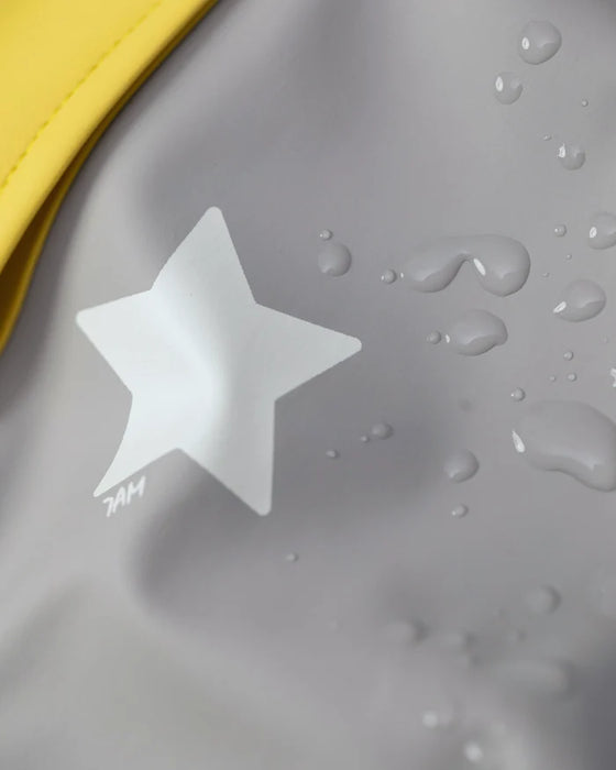 7AM rain jacket close-up showing waterproof fabric with white star print and water droplets.