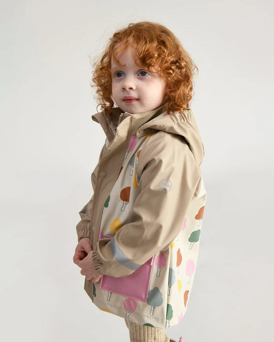 7AM rain jacket with tree print shown on a young child standing against a light background.