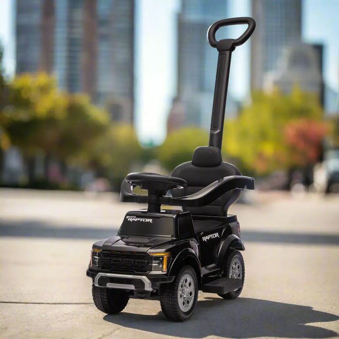 Ford Raptor ride-on push car for kids shown outdoors on a city sidewalk.